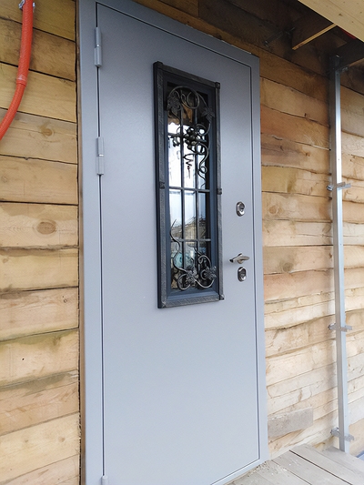 Серая уличная дверь с ковкой