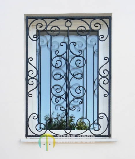 Оконная кованая решетка из завитков и прутьев Оконная кованая решетка из завитков и прутьев